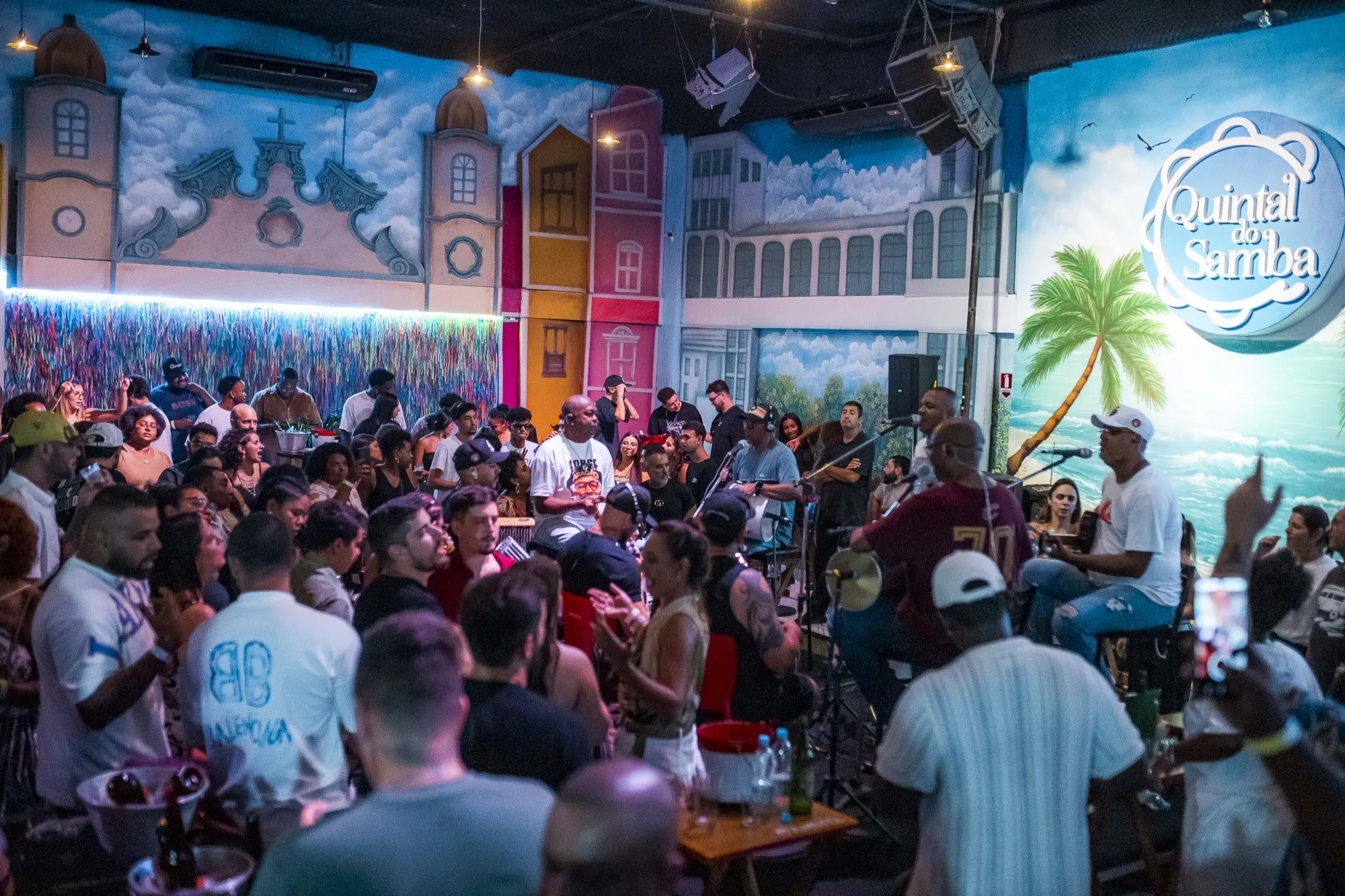 Roda de samba no Quintal do Samba numa terça, com o grupo tocando e o público em volta