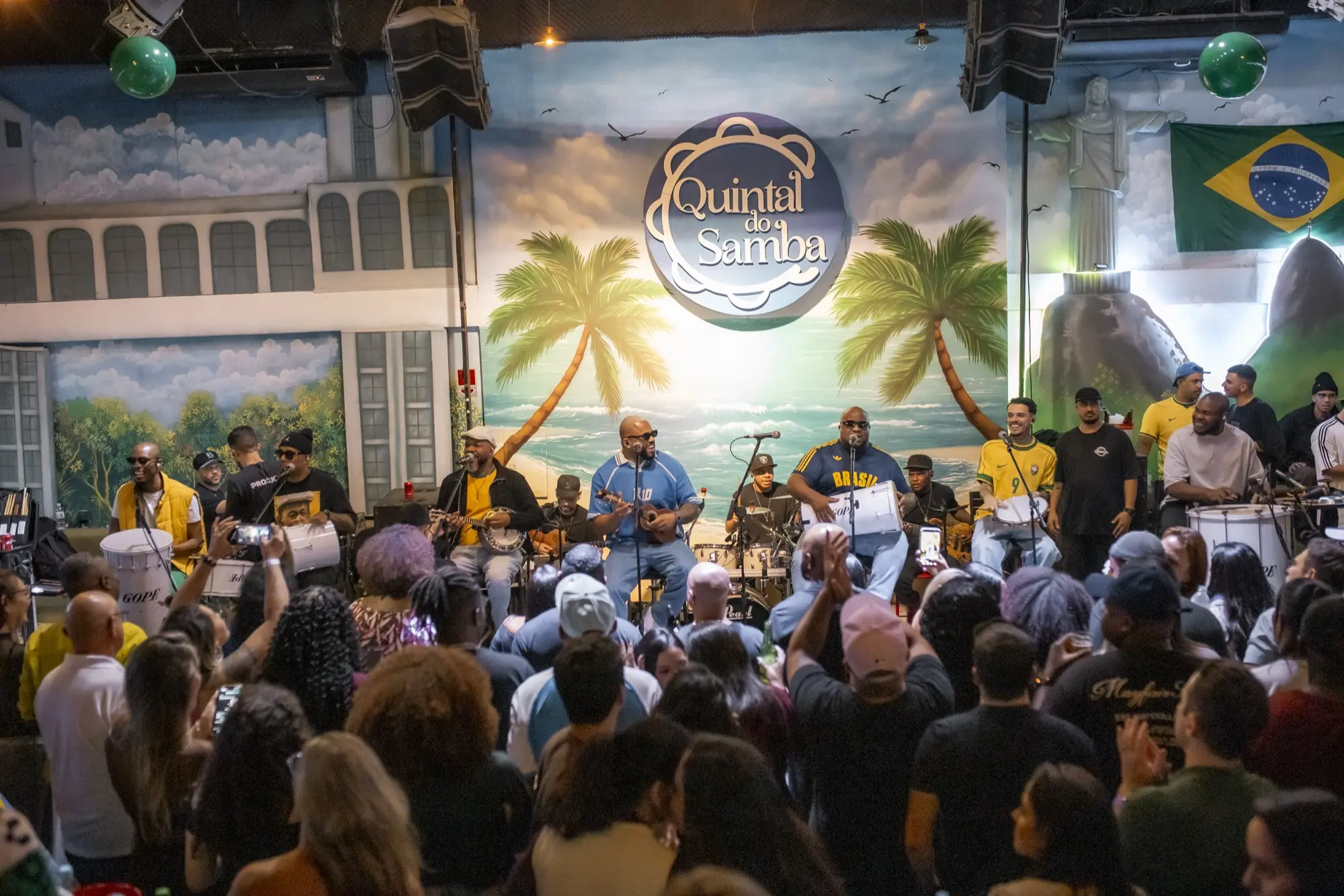 Casa cheia numa sexta no Quintal do Samba, com o público de frente para o palco
